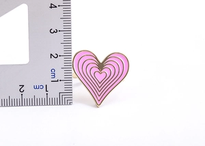 Macro view of a 25mm 18K gold plated heart ring with pink gradient enamel and ruler scale