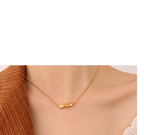 Close-up of minimalist gold plated titanium necklace with cylindrical pendant on a model
