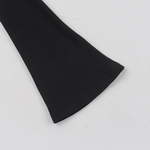 Dettaglio della trama in maglia a coste e dei polsini svasati di questo abito nero
