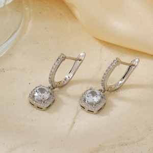 Elegant silver square hoop earrings with micro-pave cubic zirconia on silk background
