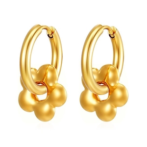 Dettaglio di orecchini huggie placcati oro 18K con ciondoli a fiore opaco su sfondo bianco