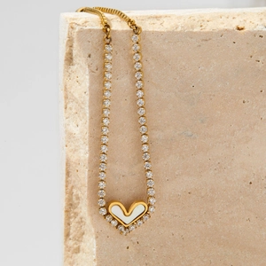 Gold adjustable heart bracelet with zircon stones and mother of pearl on stone pedestal