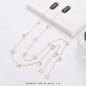 Golden butterfly hair chain with tassel and rhinestones on clean white background