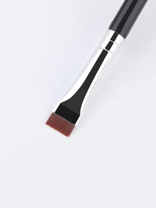 Macro detail of dual-ended flat brow and eyeliner brush with soft synthetic bristles