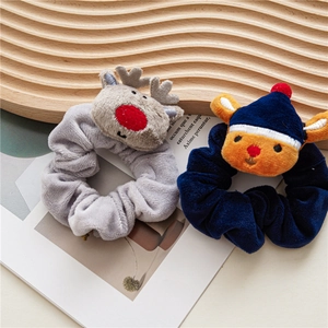 Detailed view of gray reindeer and blue deer plush scrunchies on a wooden tray