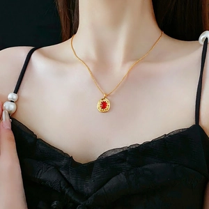 Vintage gold necklace with oval red gemstone pendant in a luxury retro design