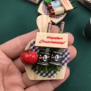 Detailed close-up of miniature wine bottle and fruit ornaments set on wooden board