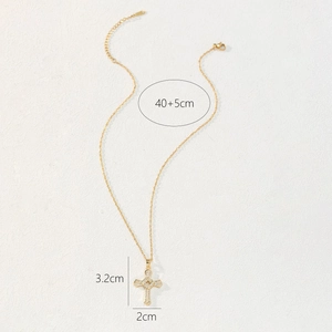 Detailed view of gold cross pendant with cubic zirconia and size dimensions 3.2cm by 2cm