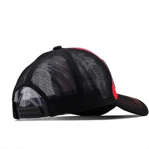 Detail of red and black mesh baseball cap with plastic snapback closure and red stitching