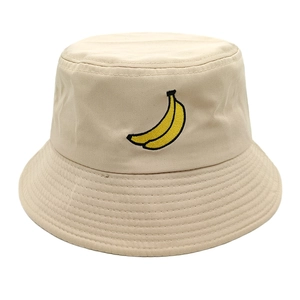 Close-up of yellow banana embroidery on a beige cotton bucket hat with stitching details