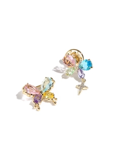 Detailed macro of asymmetric butterfly earrings with colorful gems and star pendant