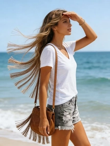 Detail showing white V-neck cotton t-shirt with fringe bag and ripped denim shorts