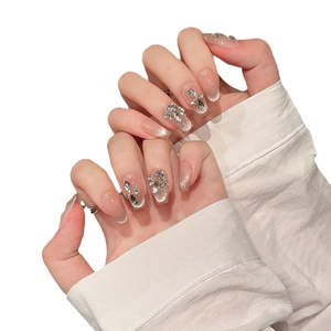 Handmade cat eye press-on nails with sparkling butterfly rhinestones and macaron pink base