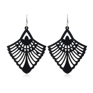 Close-up of black hollow wood earrings with geometric fan and diamond patterns
