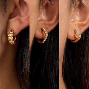Lot de trois boucles d'oreilles dorées en titane martelé et serties de zircons fins