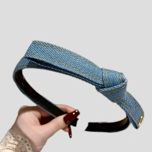Blue denim knotted headband with yellow stitching and minimalist fashion style for women
