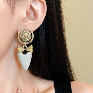 Vintage gold heart earrings with ribbon bow and Greek key pattern on ear lobe