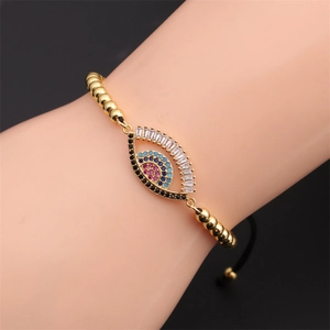 Close-up of golden evil eye beaded bracelet with colorful zircon stones and pull cord