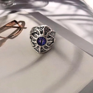 Detailed view of silver punk ring featuring a purple devil eye and intricate carvings