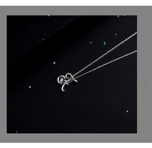 Detailed macro view of silver necklace featuring a sparkling zircon in a curvy pendant
