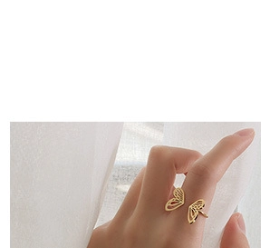 Detailed view of an 18K gold butterfly ring with hollow carving on a hand model