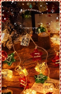 Festive Christmas LED string lights with star and gift box ornaments on wooden base