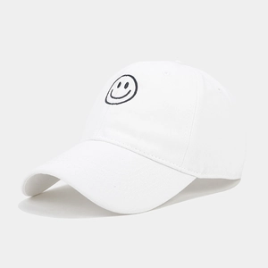 Close-up of black embroidered smiley face on white cotton twill baseball cap fabric
