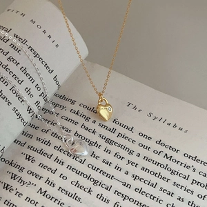 Detail of silver and gold heart pendant necklaces with for me engraving and zircon