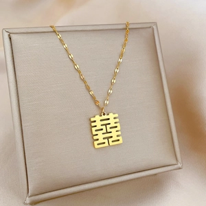 Close-up of gold-plated titanium steel necklace with Xi character pendant on silk