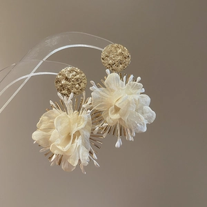 Detailed macro view of retro floral chiffon petal earrings with golden hardware accents