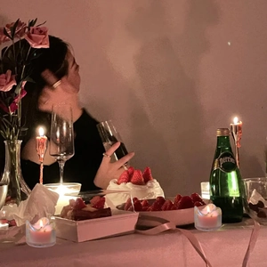 Rosa Duftkerzen in Glashaltern auf einer romantisch gedeckten Abendessenstafel