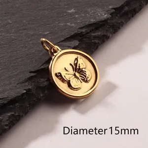 Golden round butterfly relief pendant with 15mm diameter shown on dark stone background