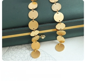 Detail of matte and polished gold disk pendants on elegant Balinese style earrings