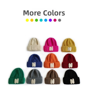 Flat lay of ribbed knit beanies in ten assorted colors featuring the signature N patch