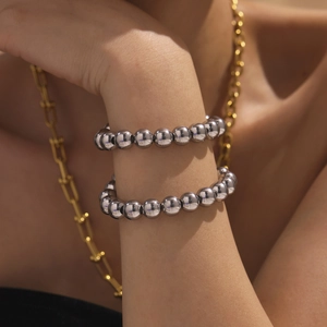 Polished silver stainless steel beaded bracelets layered on a model wrist for women