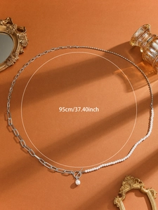 Detail of 95cm mixed chain necklace with pearls and T-bar closure on vintage background