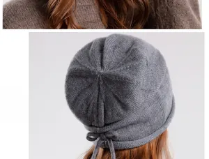 Detail view of the gray knitted beanie featuring a back drawstring bow tie design