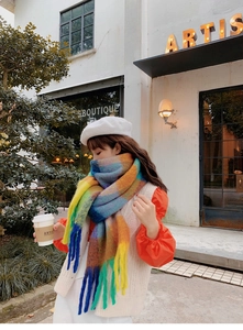 Close-up of winter rainbow plaid scarf with long tassels worn by a model in a city setting
