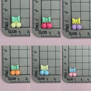 Detailed size view of colorful resin cherry charms with bows for DIY jewelry making
