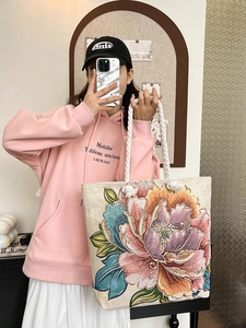 Canvas tote bag with floral embroidery and rope handles for casual fashion use