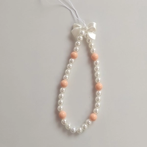 Detail of beaded phone strap with pink beads, white pearls, and a 3D bow accent