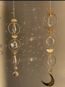 Golden sun and moon crystal suncatchers creating rainbow light reflections on walls