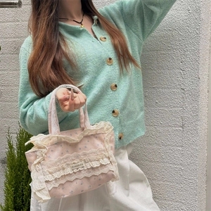 Détail d'un petit sac en toile à fleurs avec bordure en dentelle blanche et étiquette
