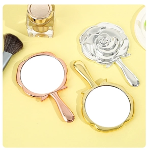 Three elegant rose-shaped handheld makeup mirrors in gold, silver, and rose gold finishes