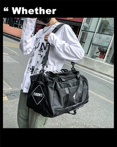 Close-up of a man carrying a large black Oxford fabric travel duffel bag in a street setting
