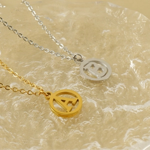 Détail de colliers avec pendentifs lettres A et B en acier inoxydable or et argent