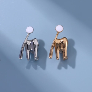 Detailed view of gold and silver dental pins with tooth and mirror design for dentists