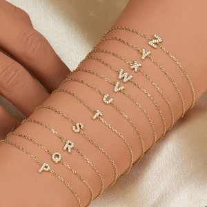 Macro shot of gold-plated 925 sterling silver bracelets with pavé cubic zirconia letters