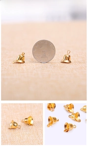 Detailed view of small golden metal Christmas bells with a shiny polished finish and top loop