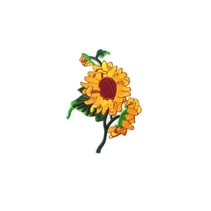 Embroidered sunflower patch with yellow petals and green leaves on white background